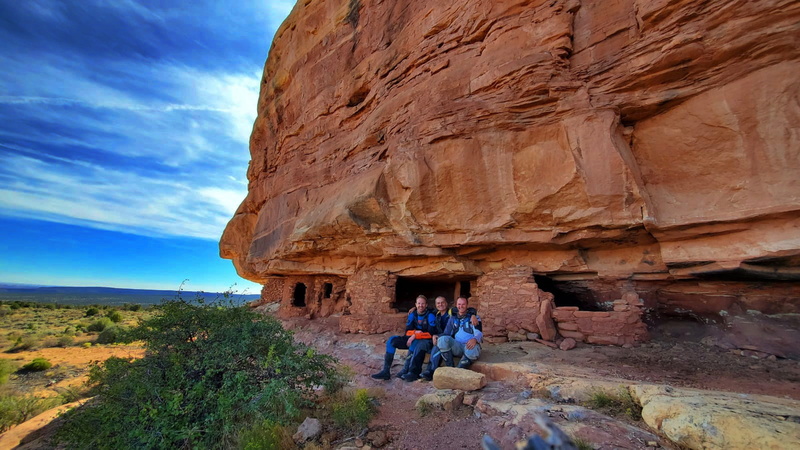 three riders by ancient rock dwellings