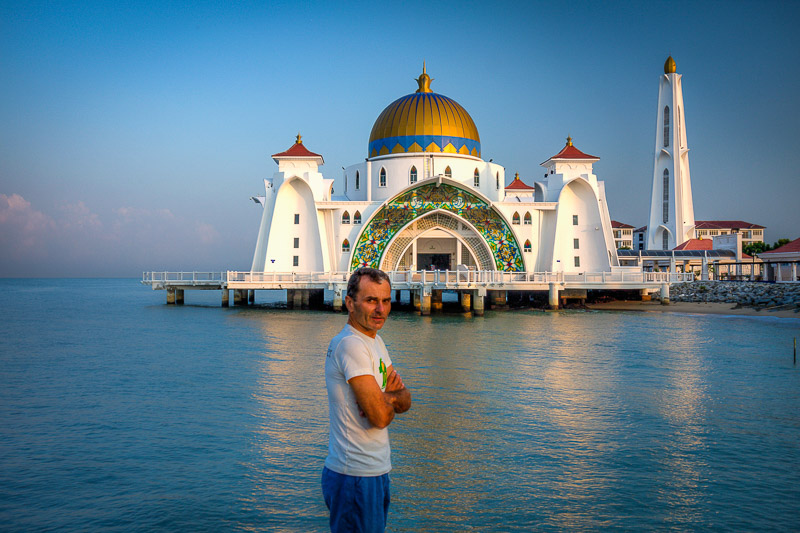 posing in front of a mosque built on water