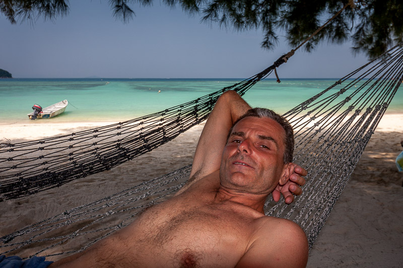 Resting in a hammock with white sand beach behind