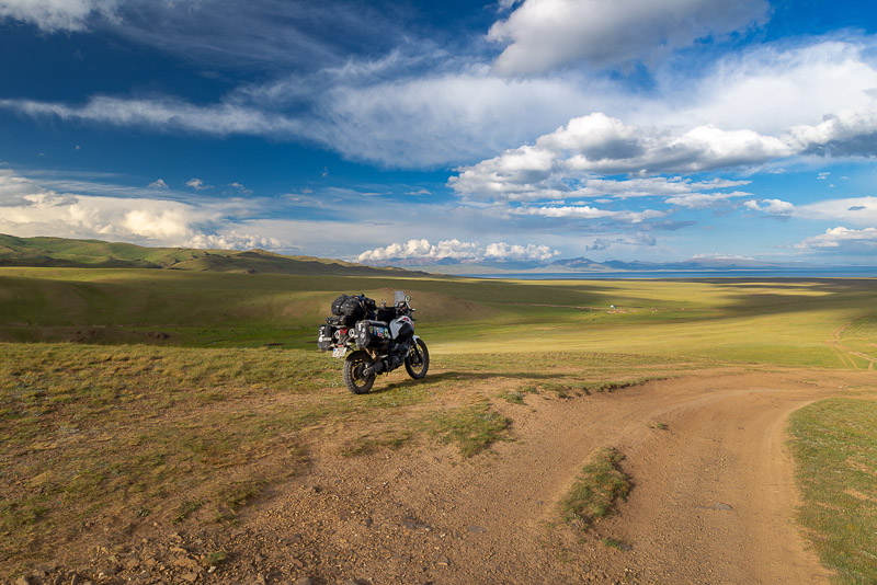 motorcycle parked on endless grass-covered rolling hills