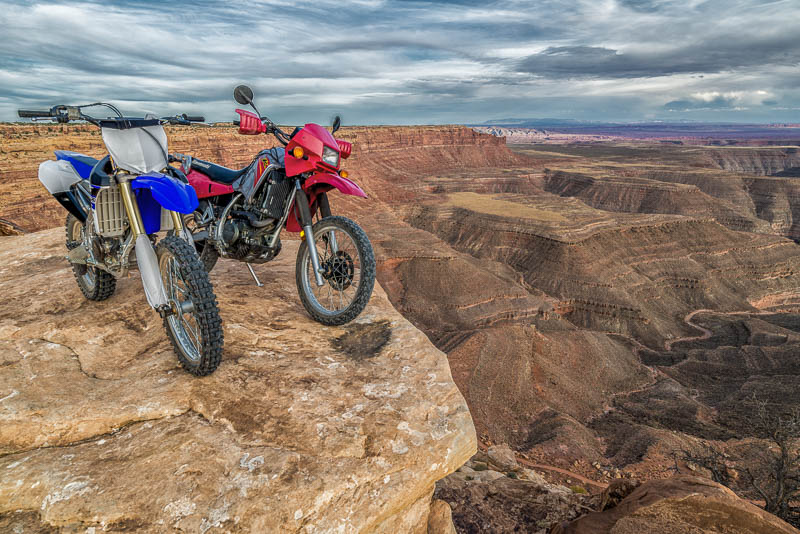 two motorcycle parked at the edge of a cliff