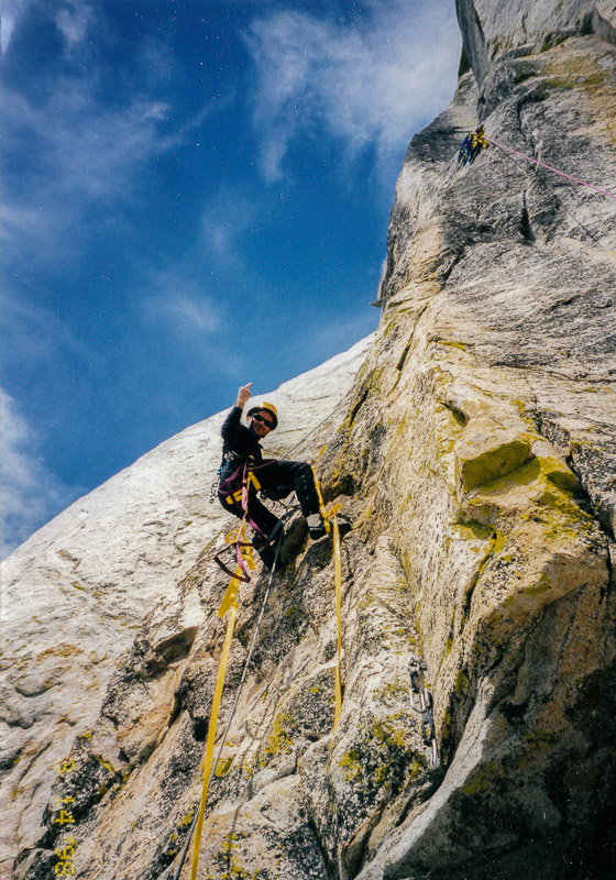 Climber roped up on a yellow rock