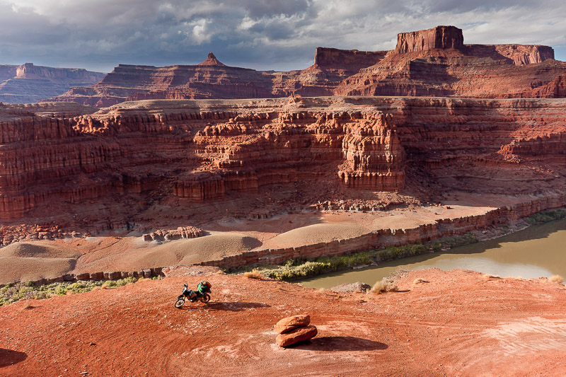 motorcycle parked near the edge of a cliff with colorado river flowing below