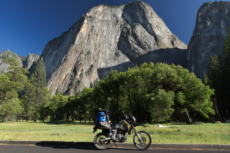 motorcycle parked in a valley with steep rock walls behind