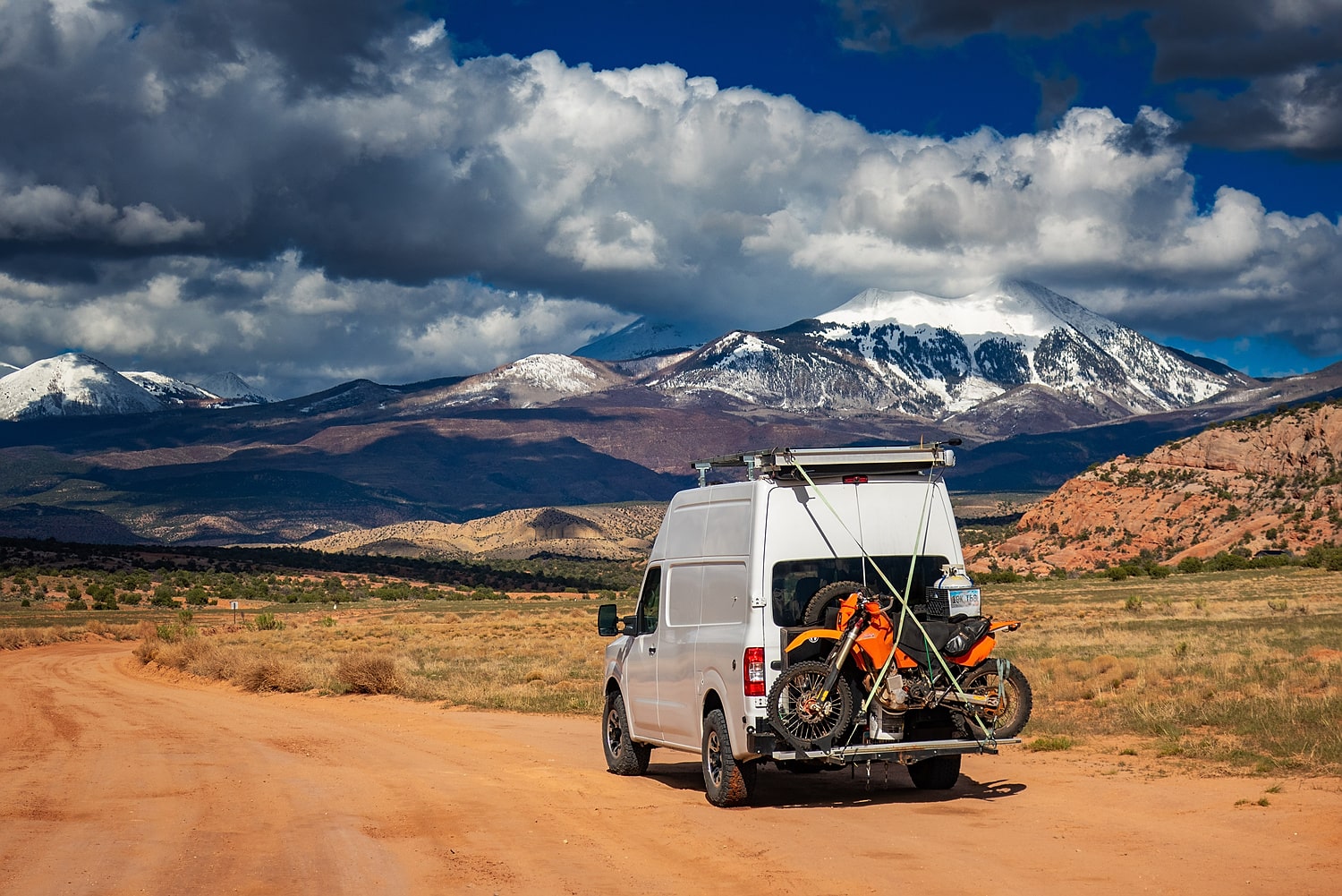 van and bike with snow capped mountains behind