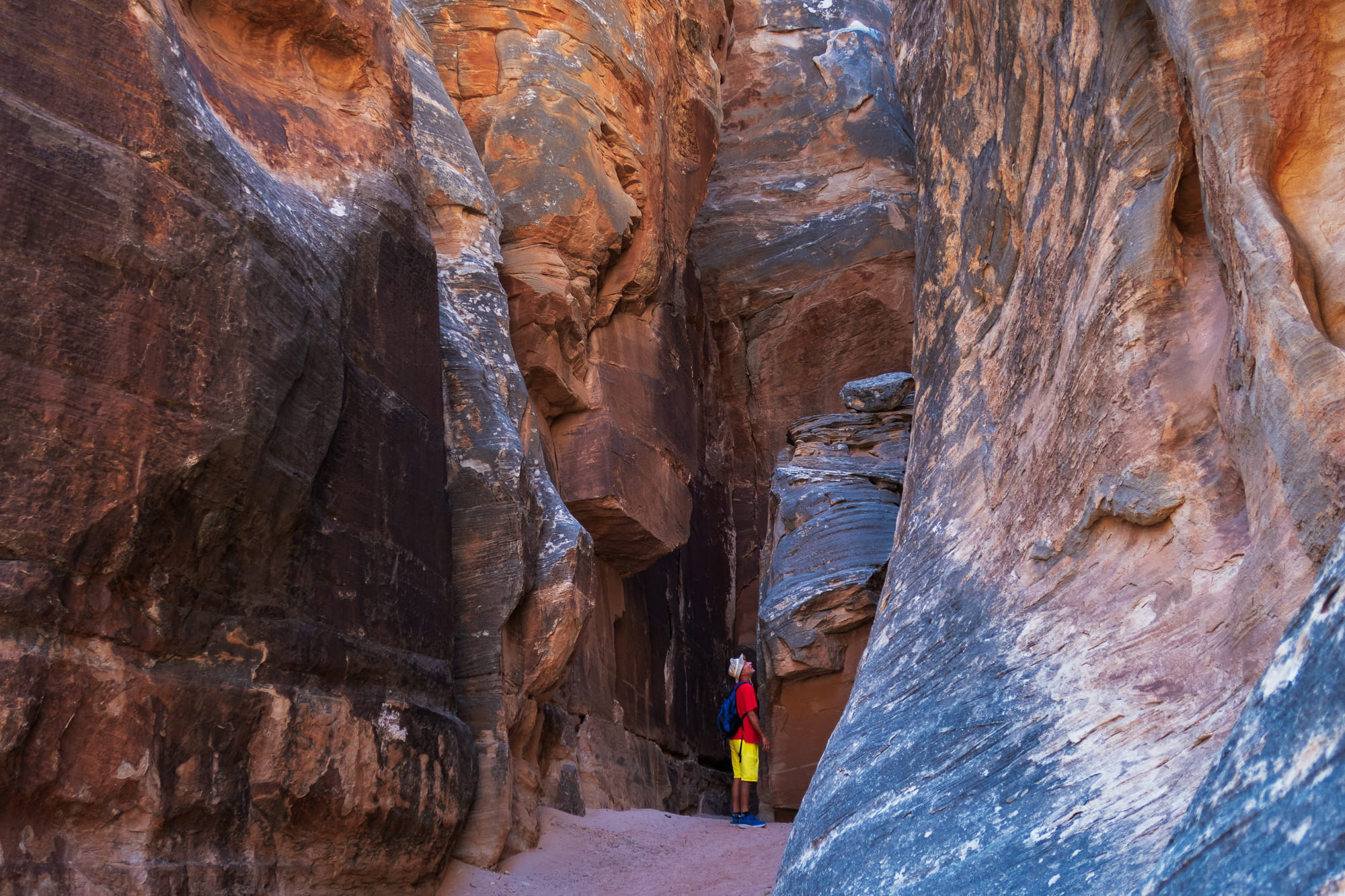 person next to steep rock walls 