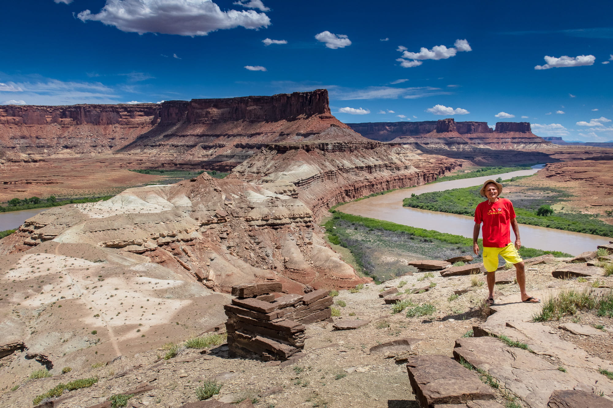 person posing high above a river and valley 