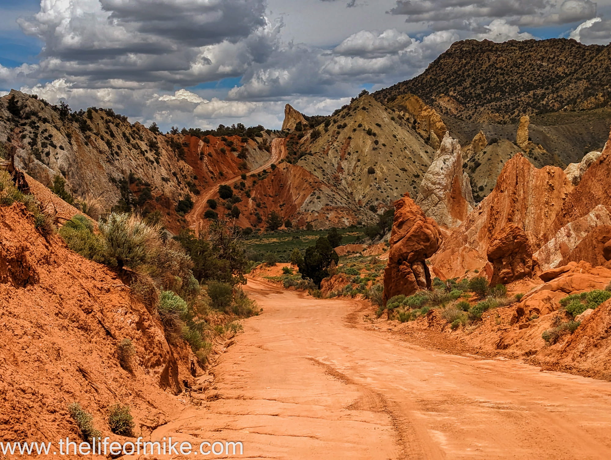 a dirt road going through a colorful canyon