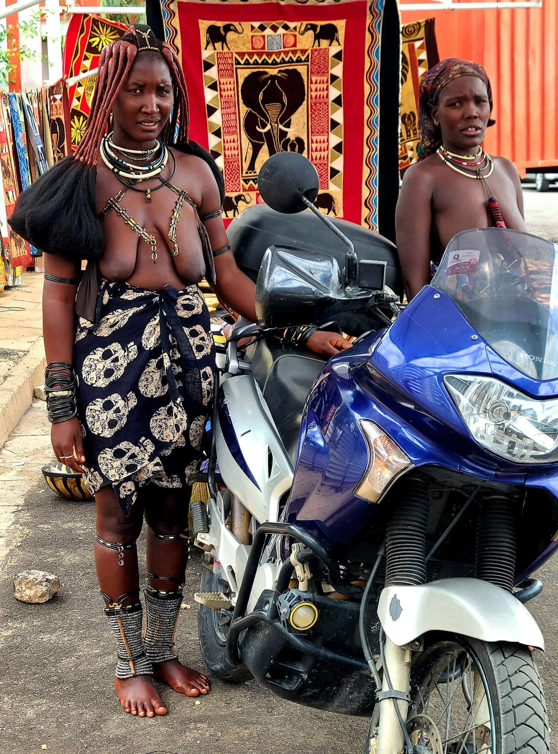 black topless girls next to a motorcycle