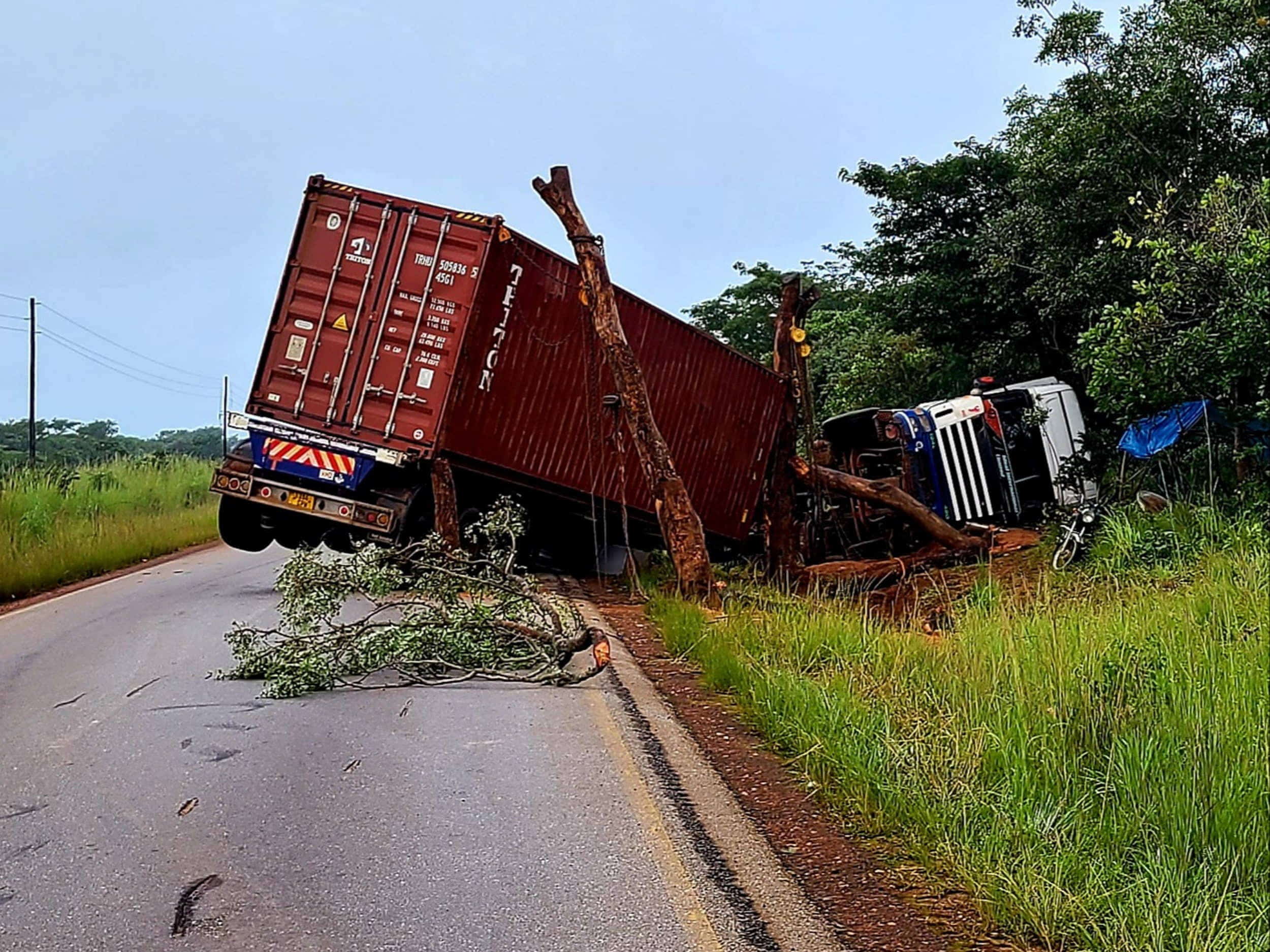 an overturned truck by the side of a road 