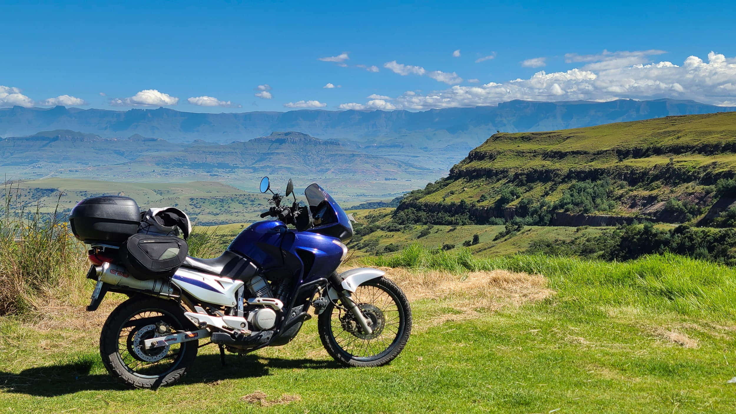 a motorcycle parked with mountains behind 