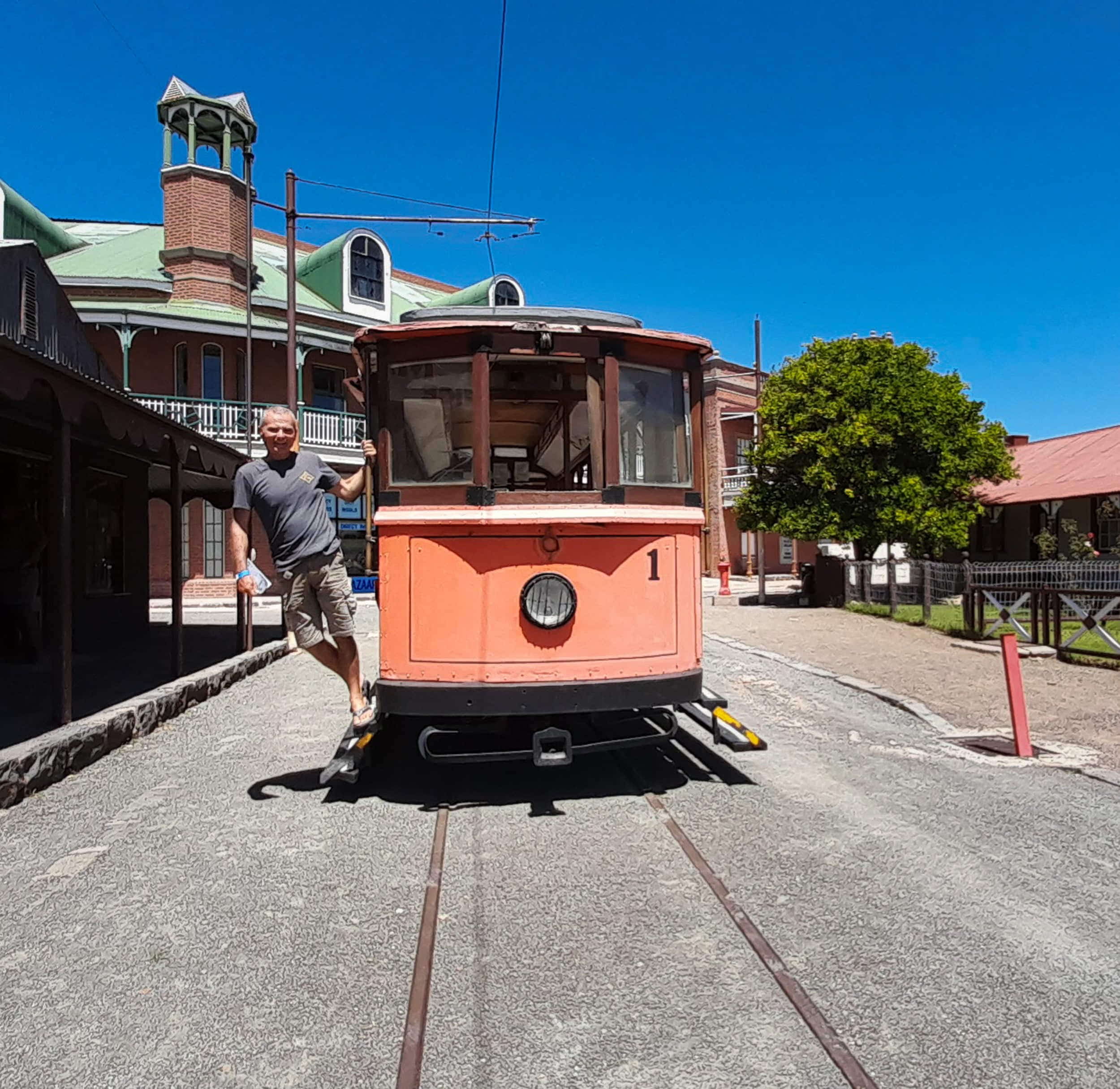 a person posing next to an old tram
