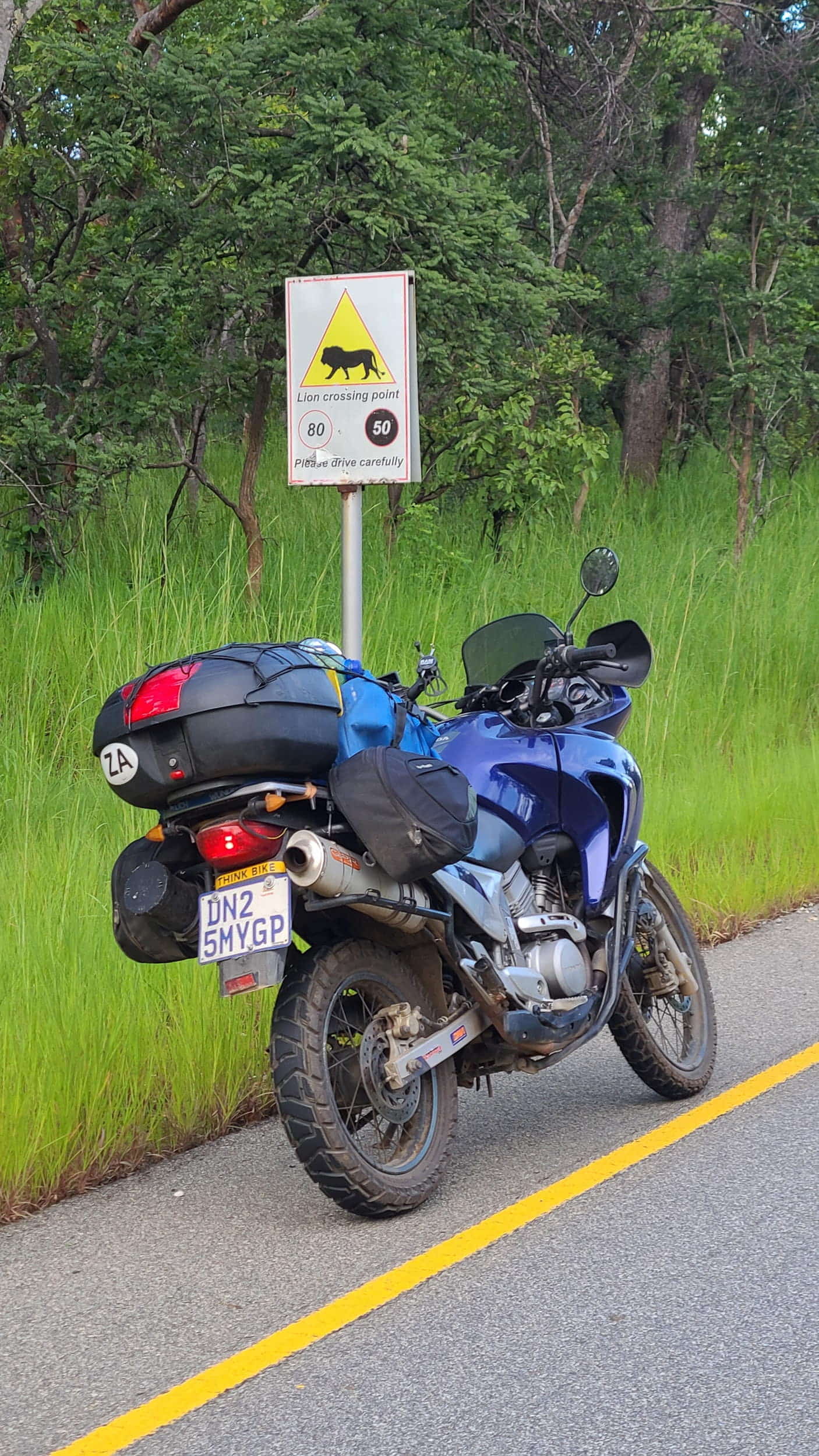 a motorcycle parked next to lion crossing sign 